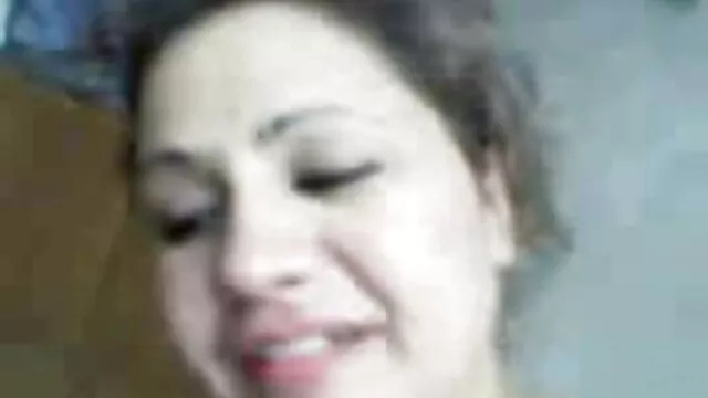 یک زن پاریسی با چشمانی زیبا به دوربین نگاه می کند کلیپ ضربدری و کیک بلند را در گلو خود نگه می دارد برای چند ثانیه.
